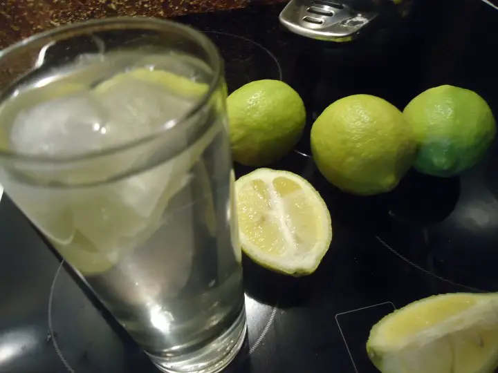 Glass of lemon water on kitchen table. 14 day challenge lemon and water diet review